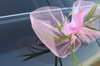 A wedding pink bow on a car door