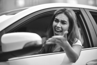 Accident. Young caucasian girl driving a car shocked about to have traffic accident