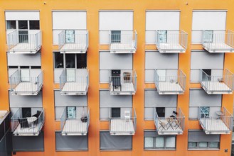 College dorm from outside, view of an orange building with grey balconies. A building where