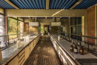 A large abandoned laboratory with numerous empty tables and glass bottles on them, Institute of