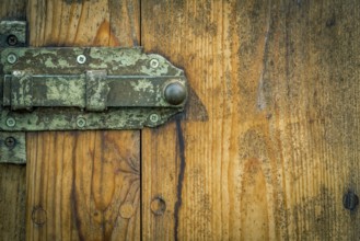 Wooden door from a german stable, with its rusty metal latch and aged wooden planks. Good frame
