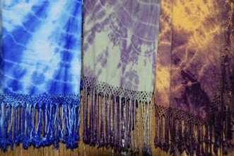 Fes, Northern Morocco, Morocco, Africa, Colourful batik scarves with fringes in blue, purple and