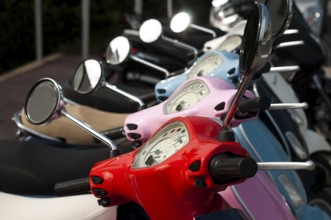 A line of mopeds/scooters on the city street