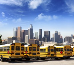 American typical school bus rear view in a row at LA skyline photo mount