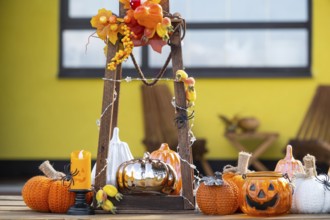 Autumn decor on the porch of the house outside in the yard of pumpkin, lantern, garlands, hats,