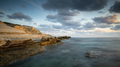 Rocky seashore seascape with wavy ocean and dramatic and beautiful sunset at sea caves coastal area