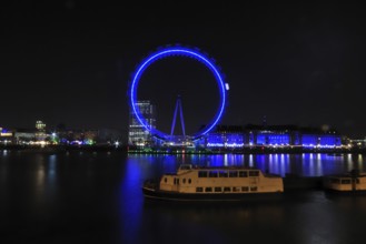 London Eye at night from the north bank with a ship in the foreground