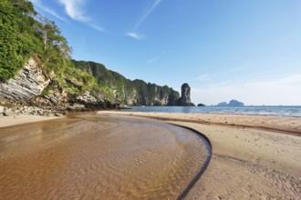 The beach at low tide. A huge puddle of sea water and bright orange sand