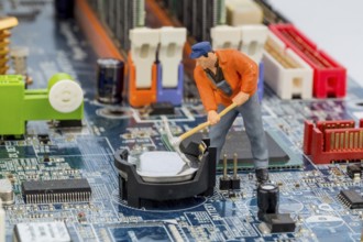 Computer board and worker, symbol photo for computer, malfunction, maintenance, data security