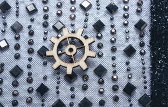 Wooden cogwheels on a fabric industry concept information