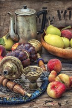 Details were worked hookah on the table amid fresh peaches.Photo tinted.Selective focus