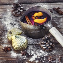 Old pot with long handle welded with mulled wine on the Christmas decor