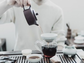 Chinese tea ceremony. Master pouring puer tea in glass teapot. Pu erh tea ceremony