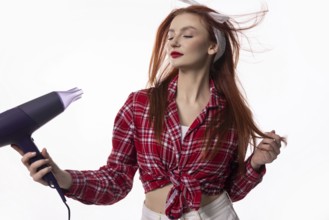 A fashionable woman enjoys drying her hair with a blow dryer, capturing a moment of style and