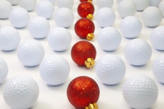 Pattern with white golf balls and red Christmas decoration on the table