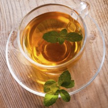 Mint tea in glass cup on wooden table