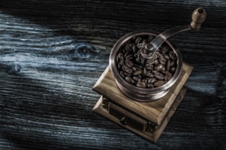 Coffee mill beans on wooden board
