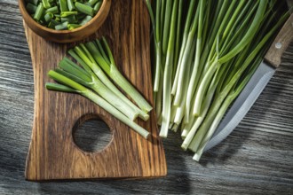Green chopped onions on wooden cutting board kitchen knife vintage wood background