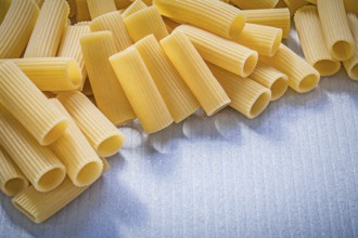 Stack of uncooked pasta on blue background food and drink concept
