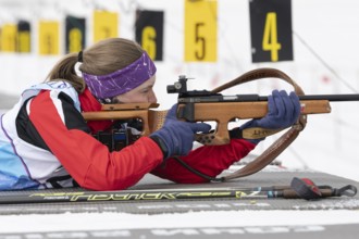 Russian sportswoman biathlete Vakhrusheva Valentina rifle shooting in prone position. Biathlete in