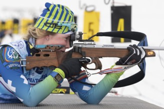 Sportswoman biathlete Anastasia Legostaeva rifle shooting in prone position. Biathlete in shooting