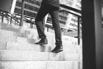 Handsome successful businessman in elegant suit outdoors walking on street in the city