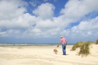 Man walking the dog at the beach
