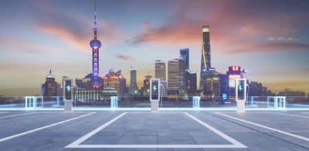 Empty parking lot with ev chargers glowing against the backdrop of the illuminated shanghai skyline