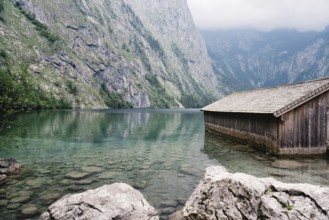 Wooden cottage in beautiful lake in the Alps with misty mood