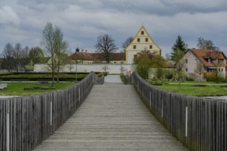 Wooden bridge leads to a historic building in a green park landscape, Tirschenreuth, Upper