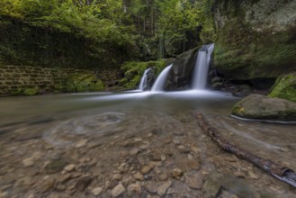 Cascade shooting pond, waterfall under small pedestrian bridge, Mullerthal Trail, Waldbillig,