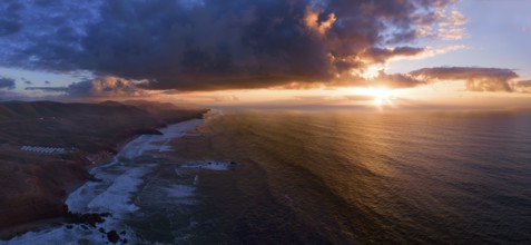 Aerial panorama of Legzira beach with arched rocks on the Atlantic coast at sunset in Morocco