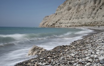 Empty pebble tropical beach under white cliffs against blue sky. Pissouri coastline Limassol Cyprus