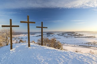 Three summit crosses on a mountain peak in a beautiful winter landscape in the Swabian Alps at