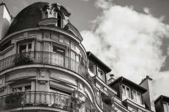 Details of a residential building with curved walls, balconies and ornate iron railings in Paris,