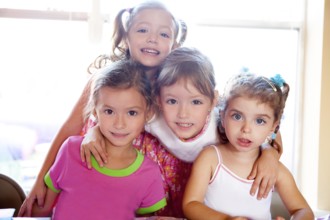 Sister and friends kid girls in hug happy together posing looking camera