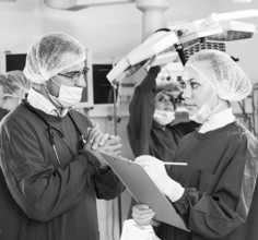 Portrait of surgeons in surgery with doctors working on background