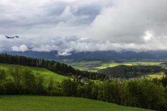 Meadow, farmland and forest area, fog in the background over Reiting massif, view from the lowland,