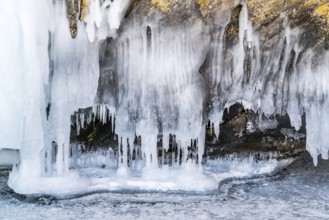 Icicles in ice cave at rocky island in Lake Baikal, Russia during winter