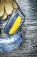 Protective glasses gloves earmuffs on wooden board