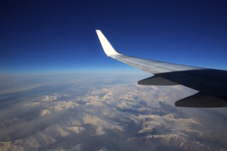 Aircraft flying over snowed mountains of Pyrenees between France and Spain