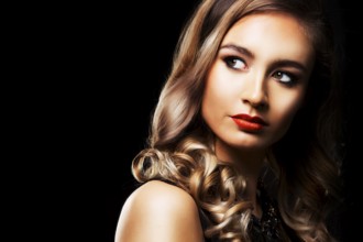 Beautiful woman with dark makeup and red lipstick posing on black background, Toronto, Canada,