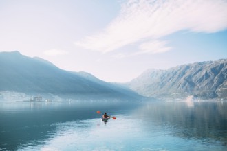 Kayaks in the lake. Tourists kayaking on the Bay of Kotor, near the town of Perast in Montenegro.