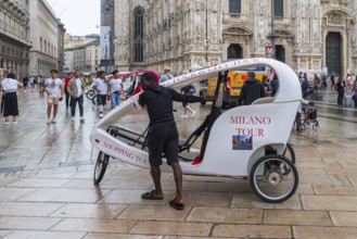MILAN, ITALY, AUGUST 4, 2021: Street vendor offering bike rides in his covered bicycle taxi in