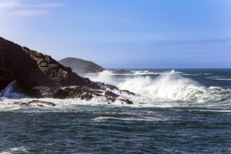 Huge waves of ocean surf beat against stone breakwaters. Magnificent Atlantic Ocean. Picturesque