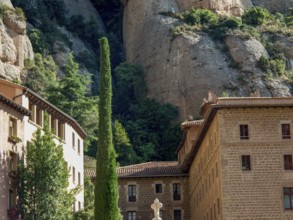 Stone building built against the rocks, surrounded by trees and vegetation, montserrat, spain