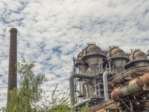 Industrial plant with chimney and metallic constructions under a cloudy sky, Duisburg, Ruhr area,