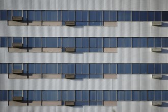 The modern façade and exterior wall of an office building with solar control windows and air