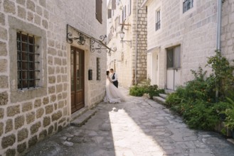 Wedding couple on the street of the old city, among ancient houses. Fine-art wedding photo in