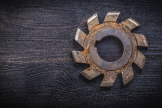Vintage rotary cutter with cogs on wood board construction concept